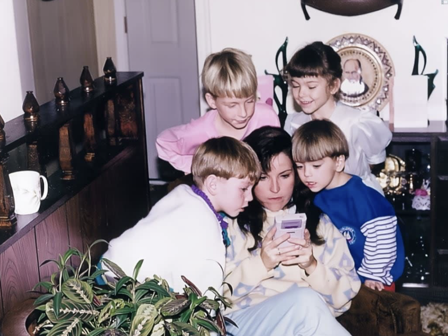 Mom helping her son through a tough level of Super Mario Land, 1989